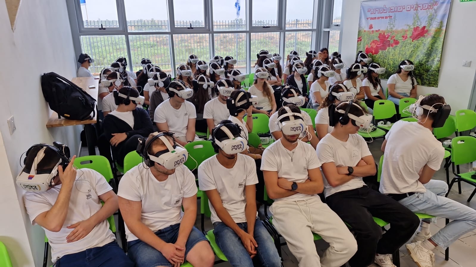 קבוצת משתתפים יושבת בכיתה ומרכיבה משקפי מציאות מדומה.